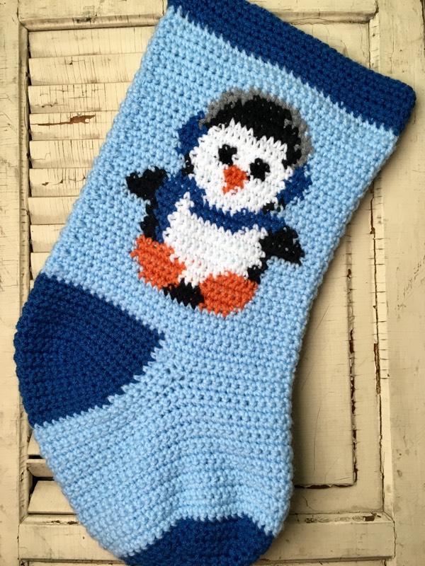 Baby penguin wearing ear muffs crocheted Christmas stocking